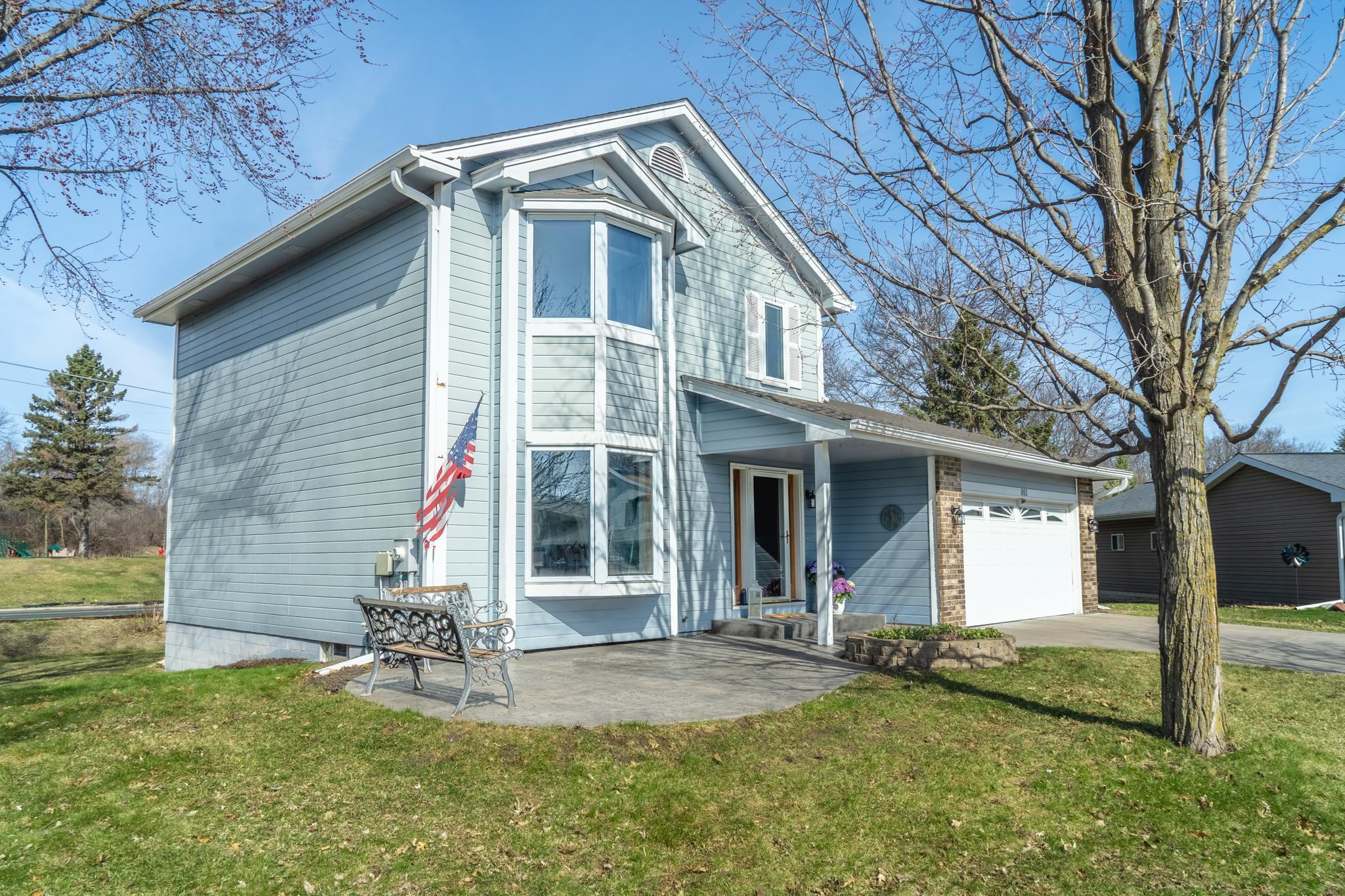 Charming stamped concrete patio, mature trees, and a welcoming entry.