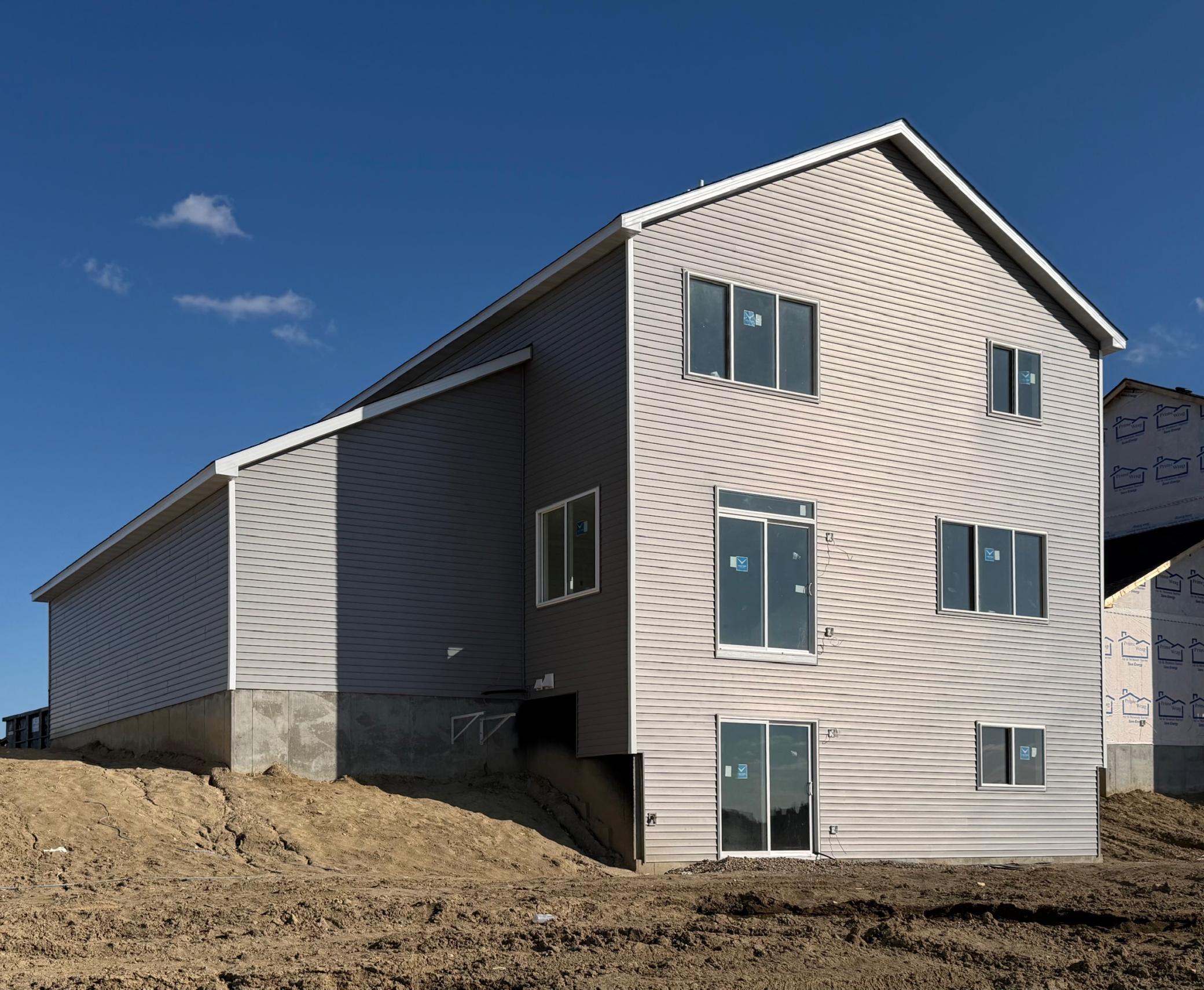 3171 Jandura Ave NE- Photo of actual home under construction. Rear elevation features a walkout lower level to a spacious backyard.