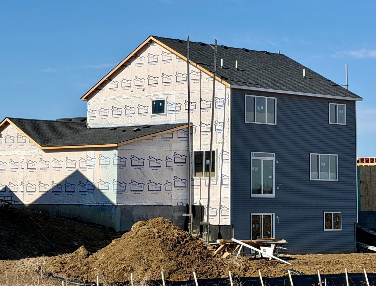 9686 32nd St NE- Photo of actual home under construction offering an estimated June move-in! Rear elevation features a walkout lower level.