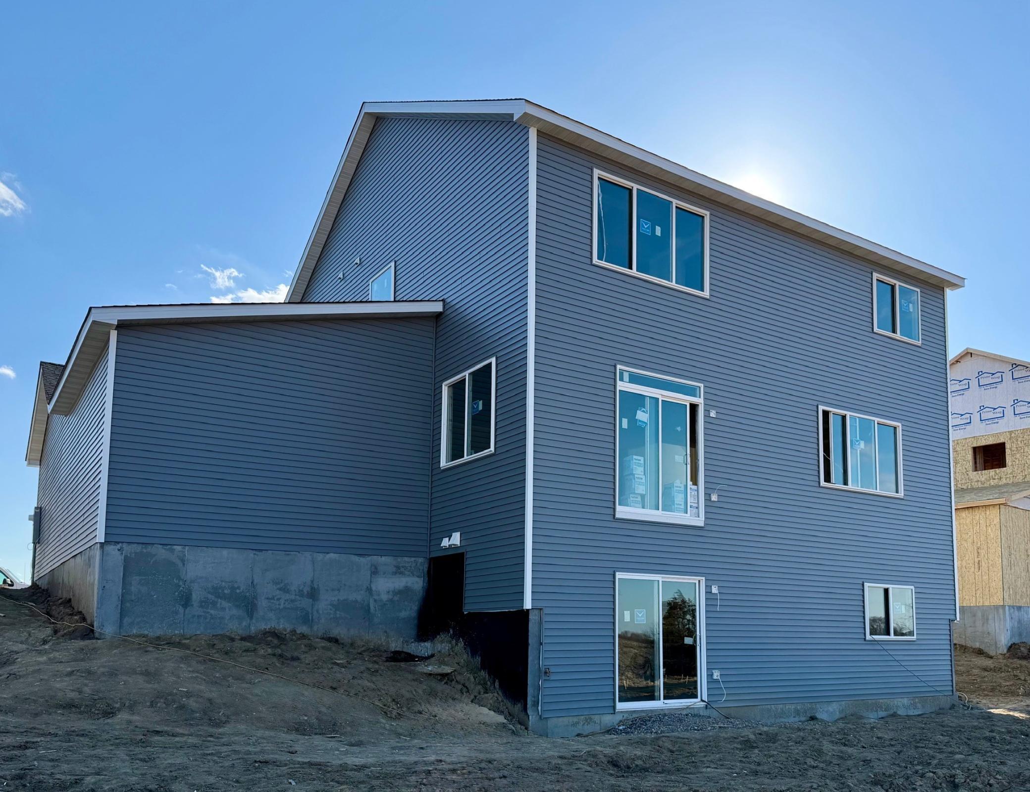 9686 32nd St NE- Photo of actual home under construction offering an estimated June move-in! Rear elevation features a walkout lower level.