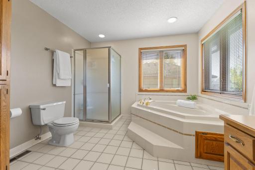 Primary bathroom ensuite with neutral tile floors, separate bath & shower and double windows with blinds. Never feel crowded again!