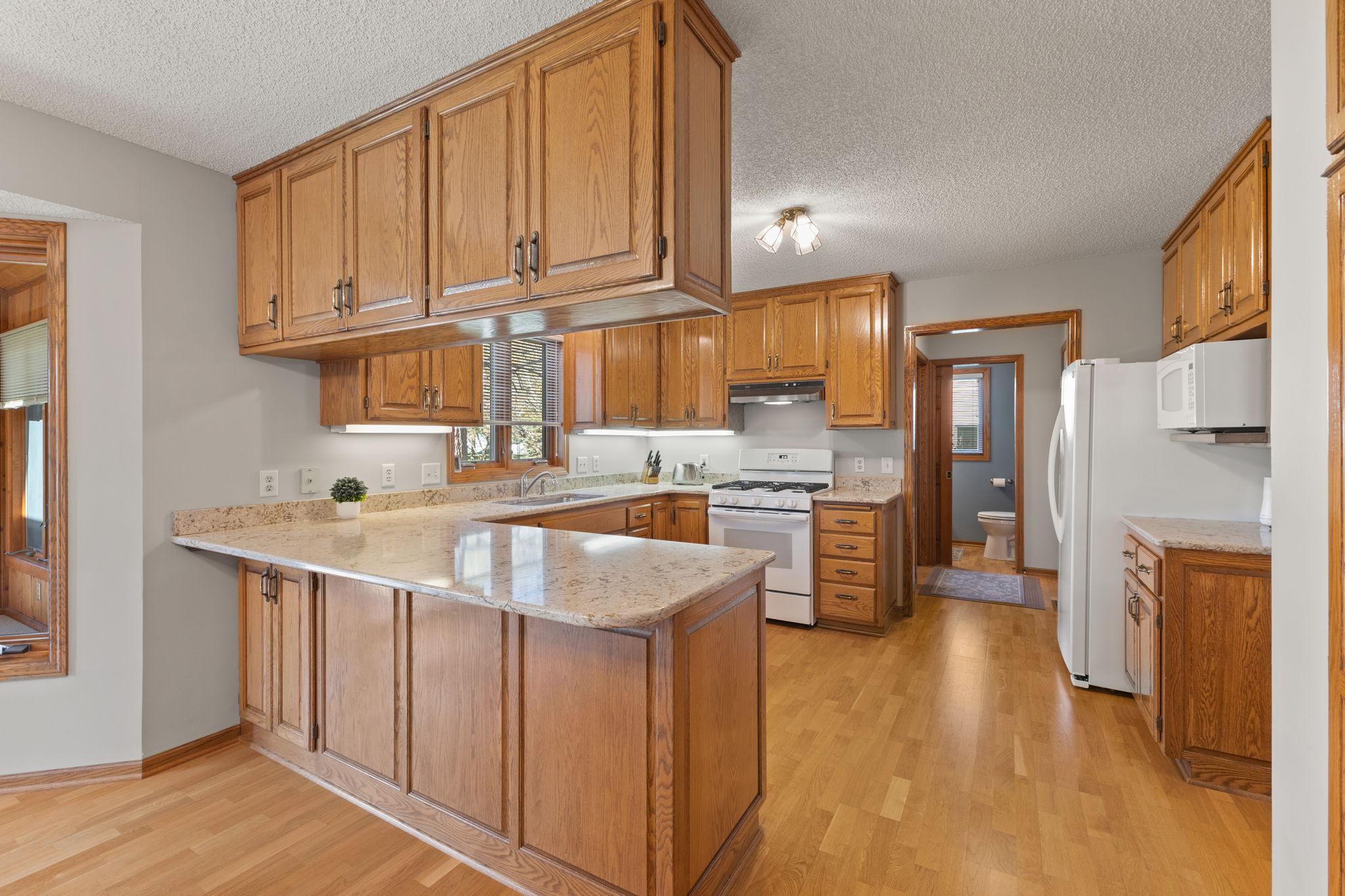 Abundance of storage with quality cabinetry, beautiful granite counters with expansive counter surface plus under cabinet lighting offer a well designed and functional space.