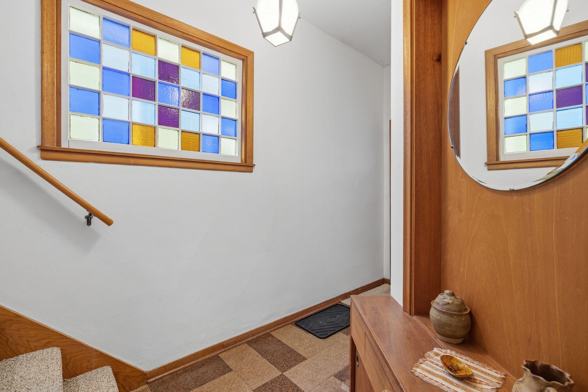 Notice the original stained-glass window upon entering the home.