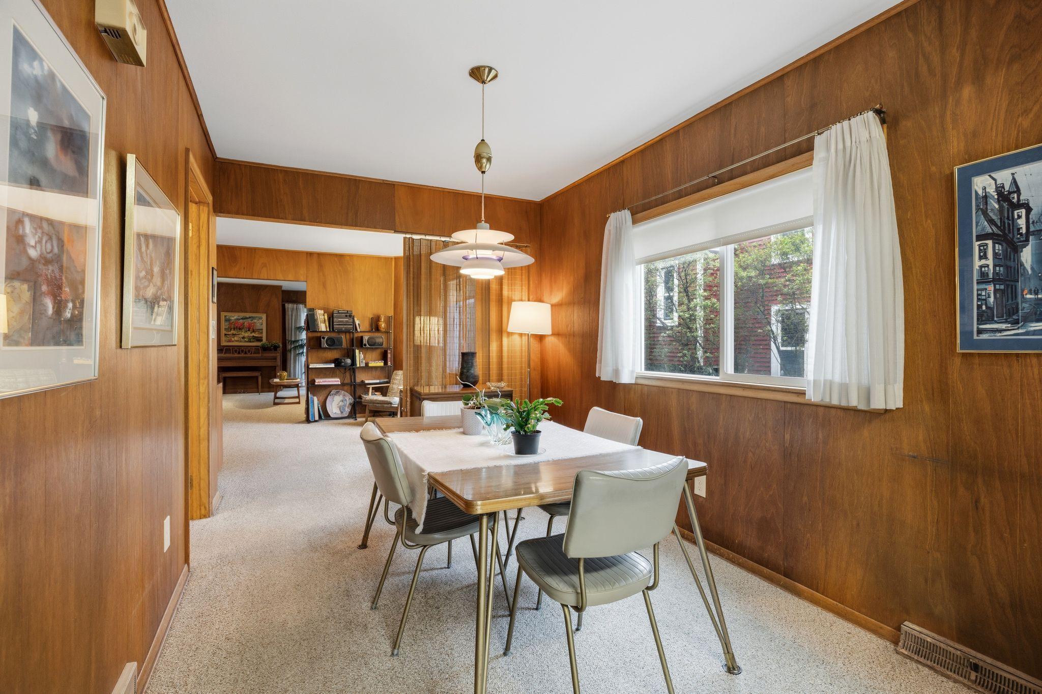 This vantage point shows the open-concept layout connecting the kitchen to the dining and sitting rooms. The sightline emphasizes the home’s airy feel and the easy transition between cooking and social spaces.