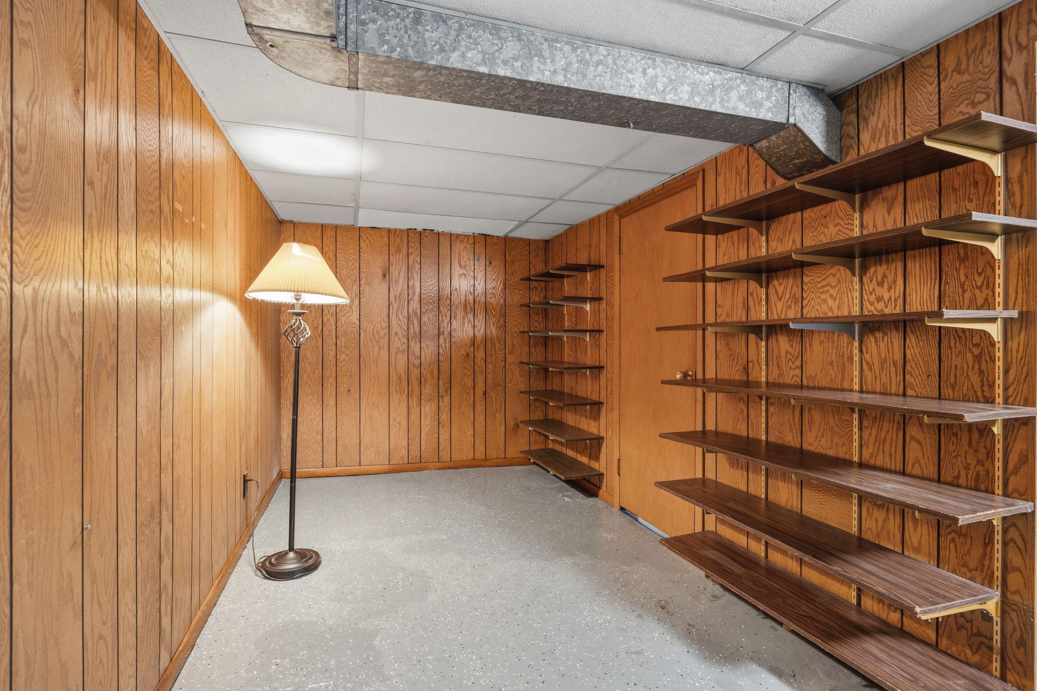 Basement space near pool table with shelves.
