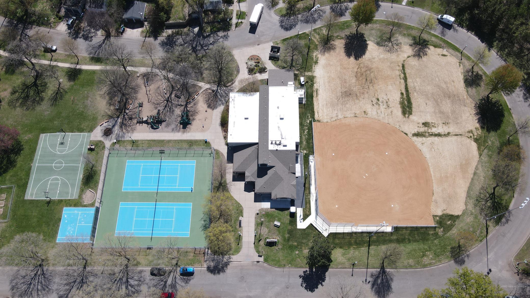 Drone photo - View of Langford Park. Notice the tennis and pickleball ball courts, playground, recreation center that has a variety of events throughout the year, and ball field. In the winter, ice rinks are installed on top of the ball field.