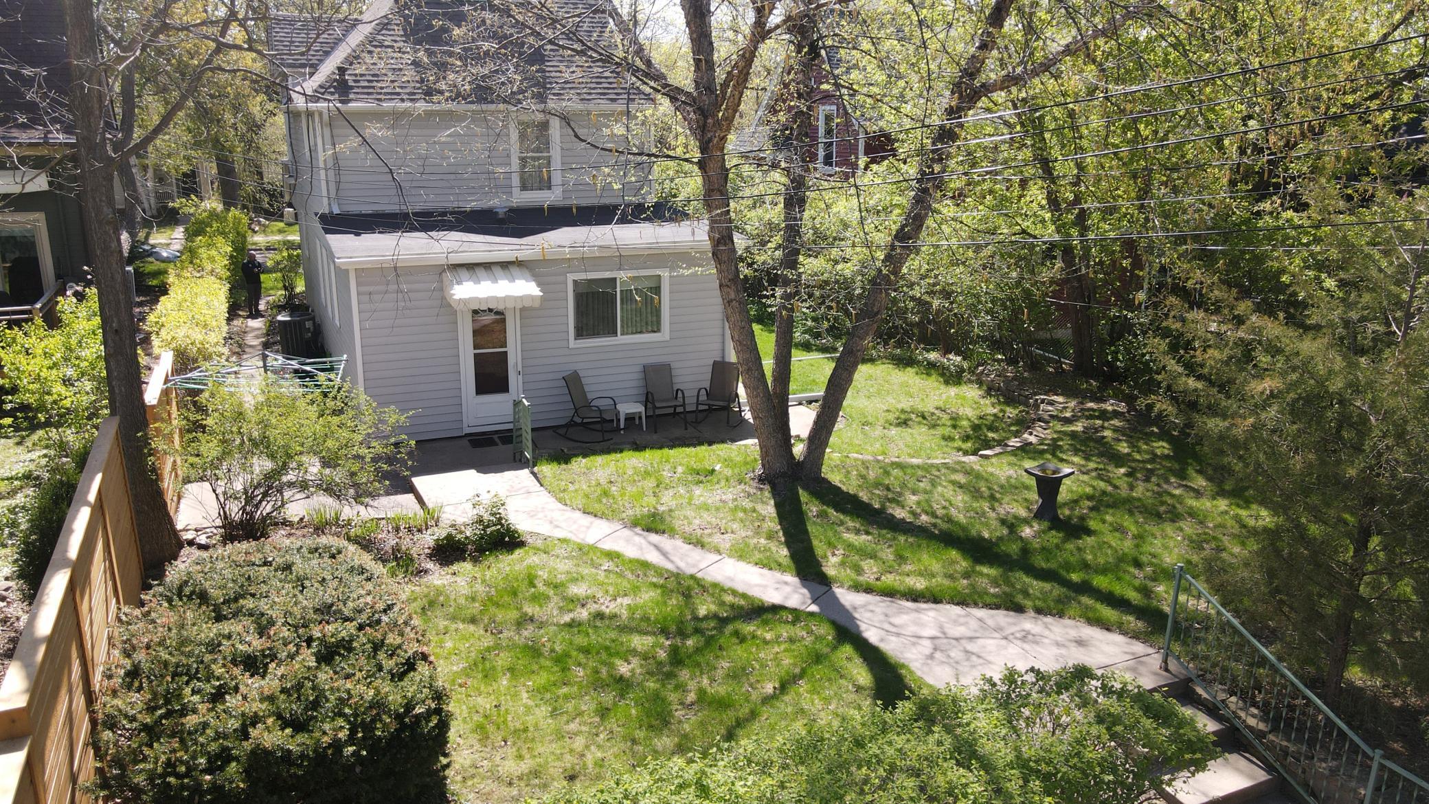 View of the back yard. There is moderate tree cover and some privacy due to the neighbor's new fence and bushes around the property.