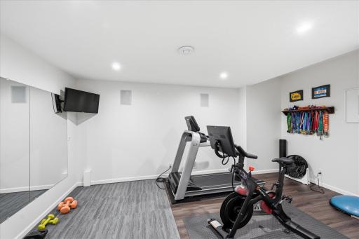 Wall mirrors and surround sound create an energizing home gym space designed to keep your workouts focused and on track.