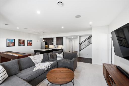 Lower-level family room designed for everyday living and easy entertaining. Soft neutral finishes highlight this open layout. The built in wet bar creates a perfect space for additional entertaining fun.