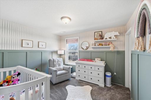 Wainscott accents this one of four bedrooms on the upper level.