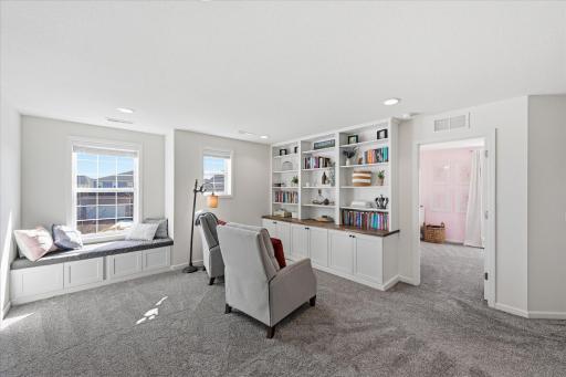 The upper level of this home has 4 spacious bedrooms plus this loft/living space with built-in shelving and a window seat.