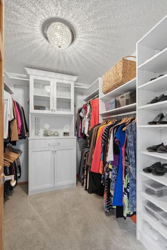 Amazing custom closet - white enamel, crystal light, hanging space, shelves and glass door cabinet.