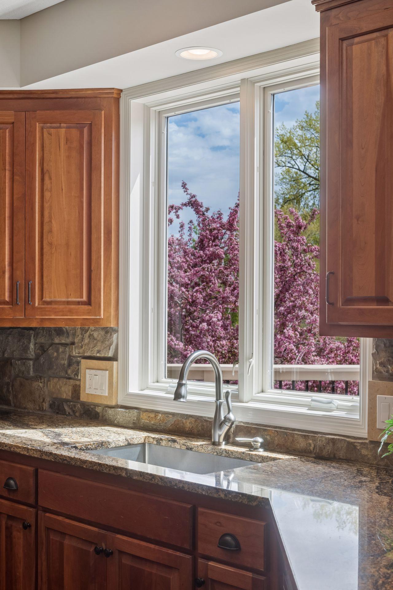 Large kitchen window overlooking beautiful landscaping in your private backyard