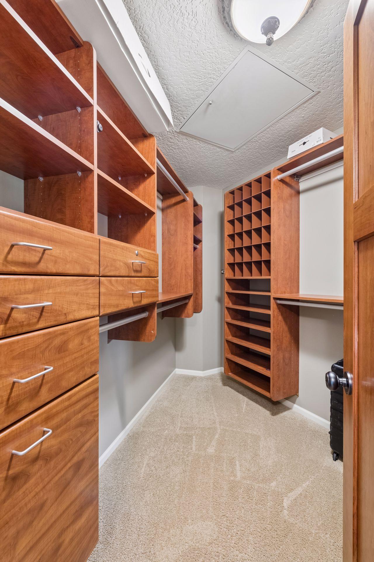 1 of 2 large primary bedroom closets with custom built ins