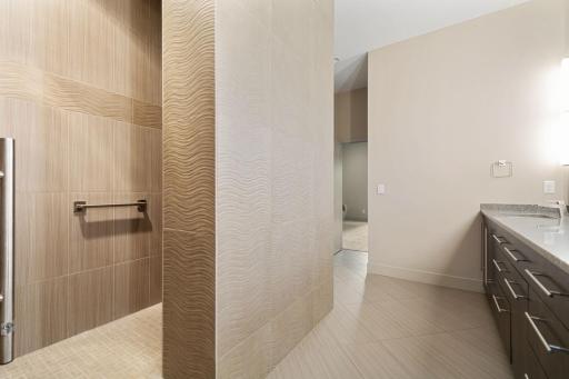 Primary luxury bathroom with open walk in shower and high end tiles