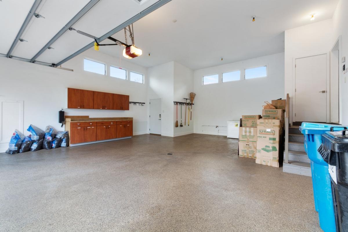 Massive oversized heated garage with epoxy floor and ample storage.