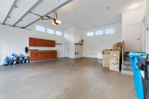 Massive oversized heated garage with epoxy floor and ample storage.