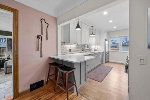 Remodeled kitchen with quartz countertops, custom backsplash, stainless steel appliances and cork flooring.