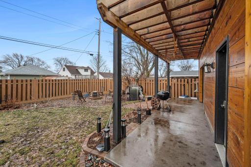 This is the back of the garage that has a patio, custom pergola and it's own garage door for easy access to the yard.