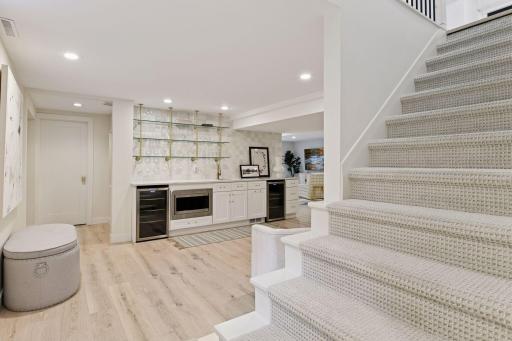 The lower level is designed for entertaining and relaxation, featuring a renovated family room with fireplace, new wet bar, home office, exercise room, and guest bedroom with adjacent three-quarter bathroom.