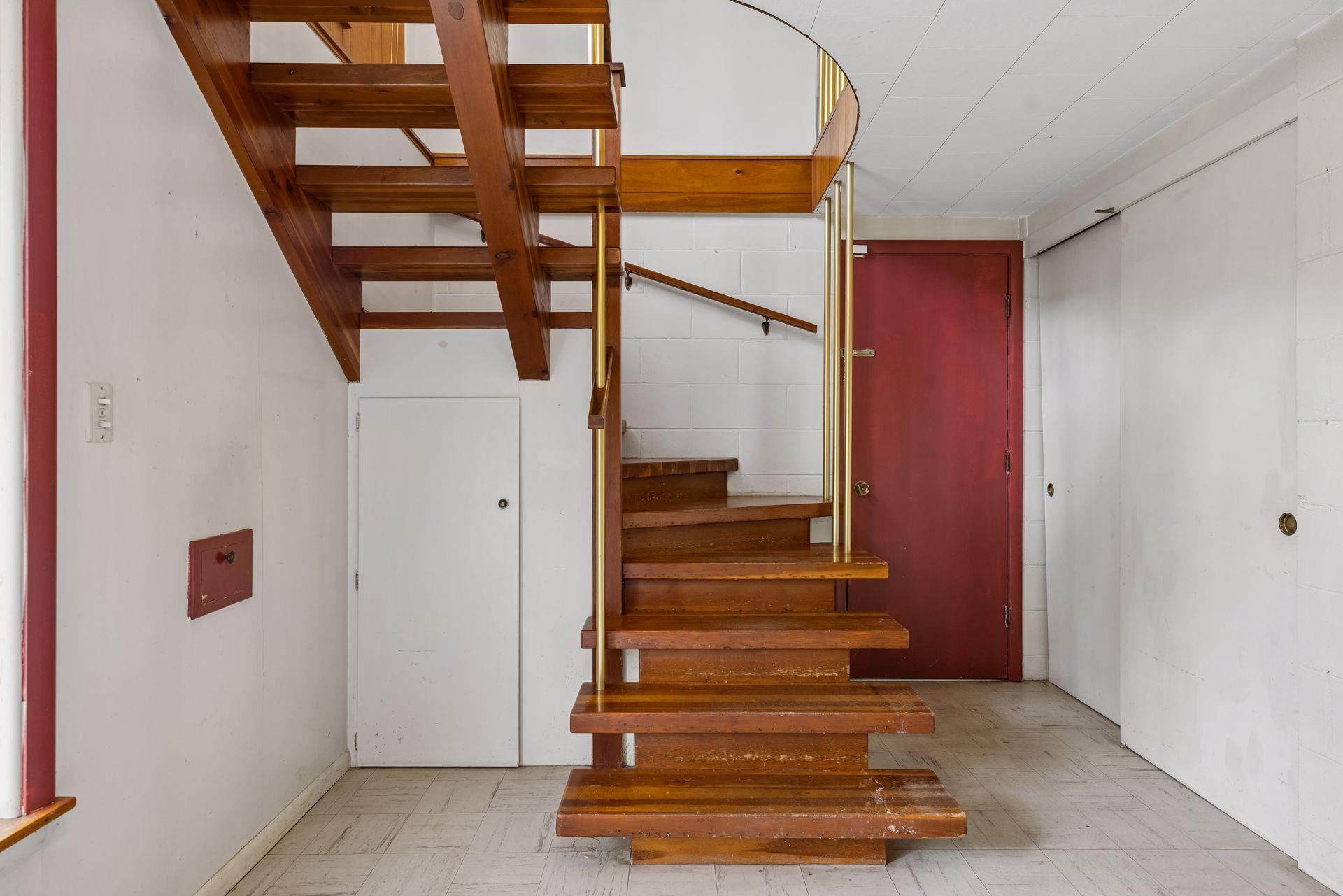 Hardwood treads, gentle spiral staircase leads to front entry.