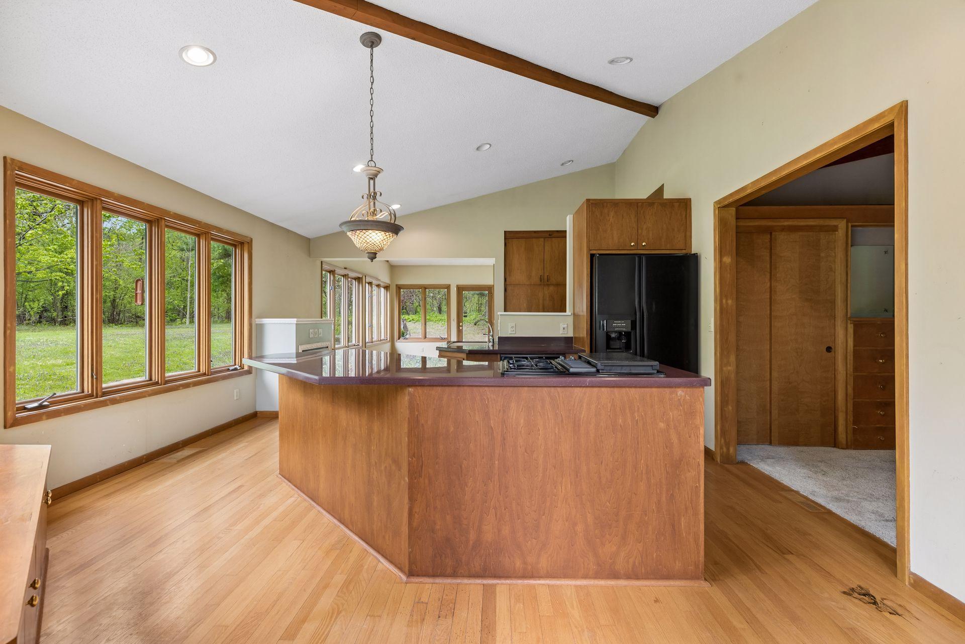 Kitchen with gas cook top and down-draft exhaust fan. Kitchen opens to office. Bring your MCM renovation ideas. Vaulted ceilings throughout structure.