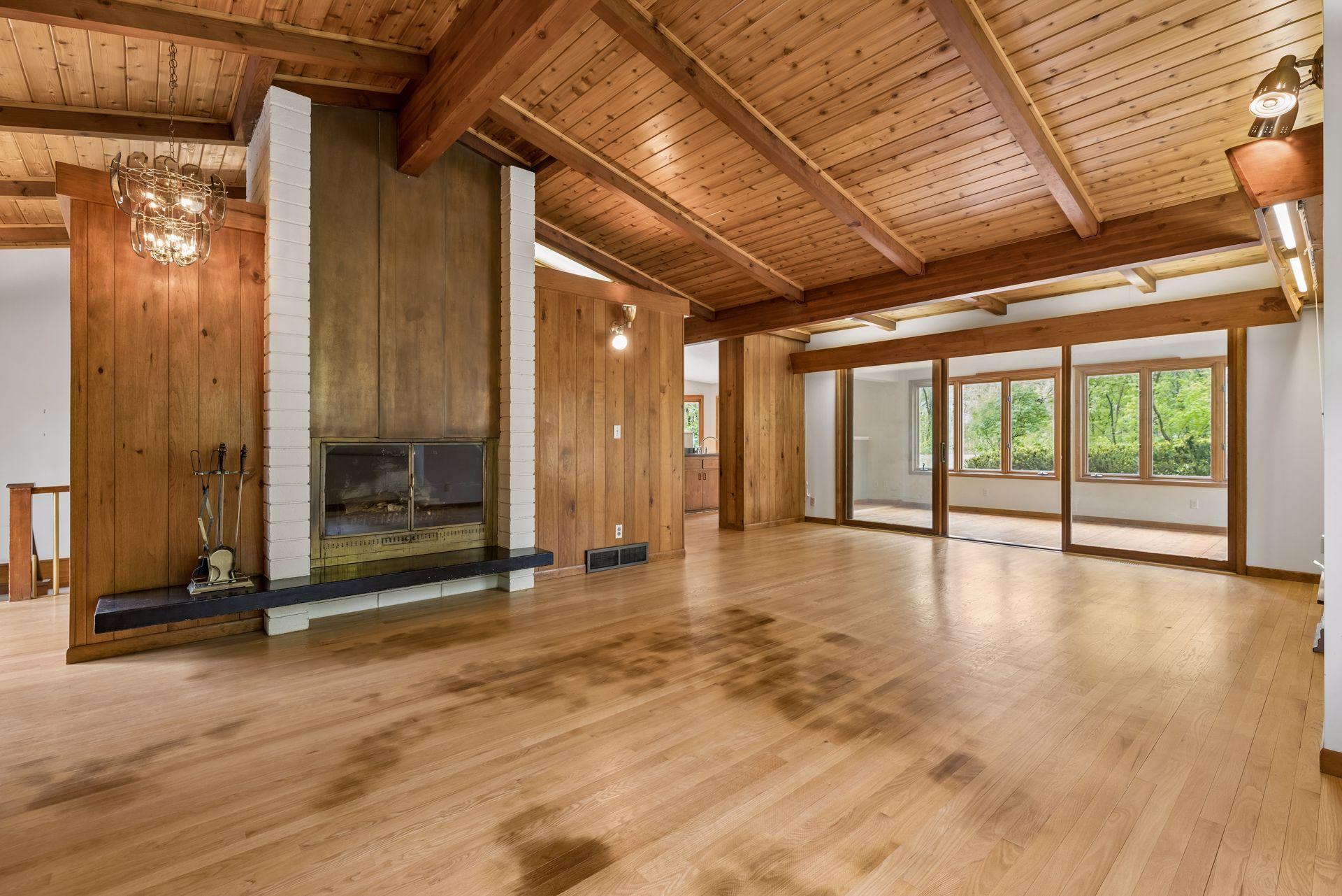A mid-century modern design. Hardwood floors in the public areas (need refinishing). Handsome details - vaulted ceilings that run throughout the structure, vintage fireplace (sold as-is).