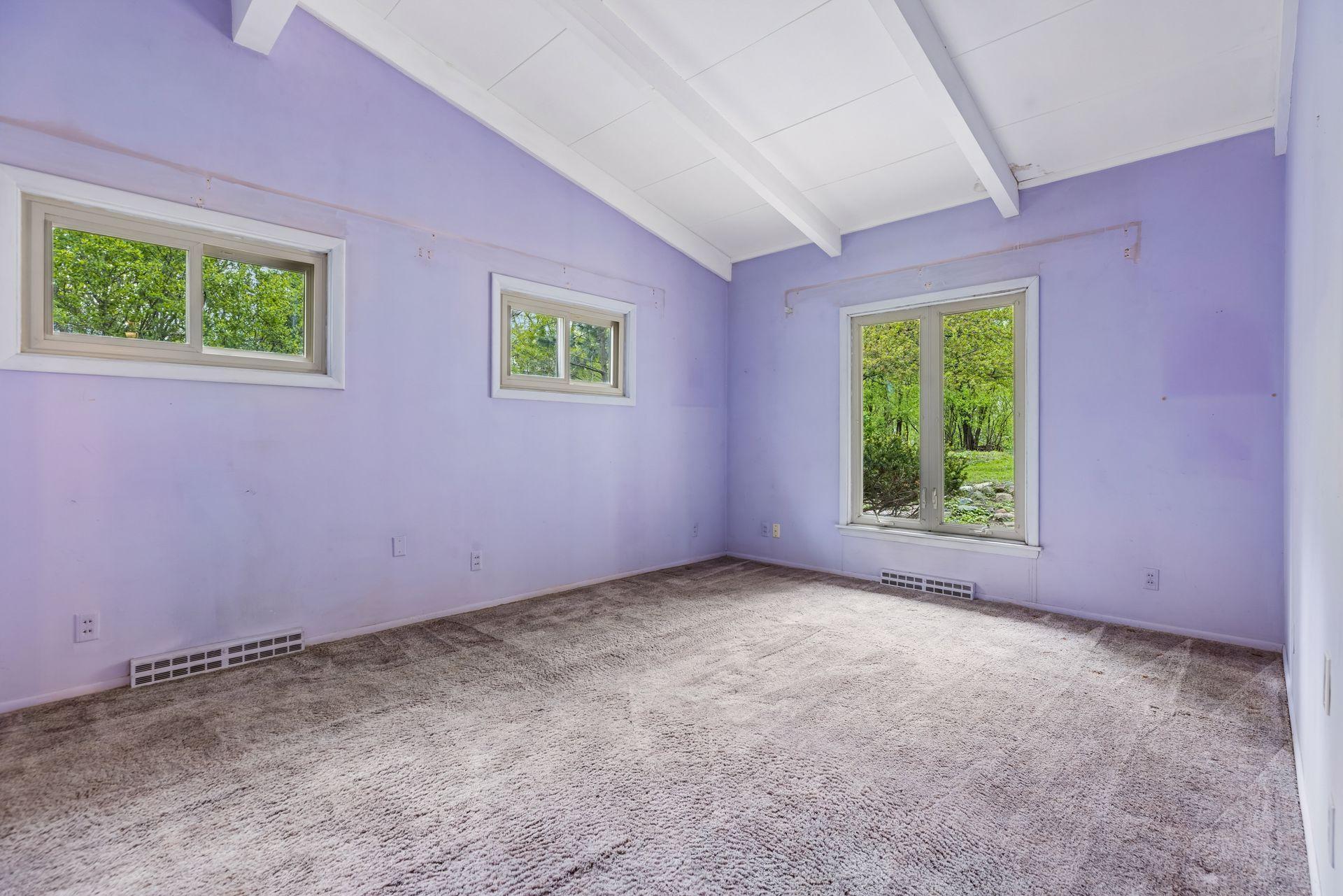 Main floor bedroom with continued vaulted ceilings. Plywood under carpet.