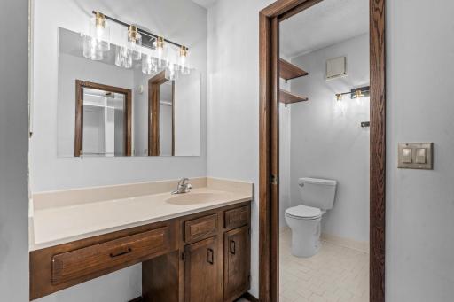 Private Â¾ bathroom featuring a walk-in shower, tile flooring, a single vanity, and a separate water closet with a pocket door.