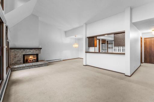 As you enter this south-facing unit, you are greeted by soaring ceilings and a spacious living room filled with natural light from large windows. The living area features a cozy gas fireplace, carpeting, and access to a 13x5 screened-in deck.