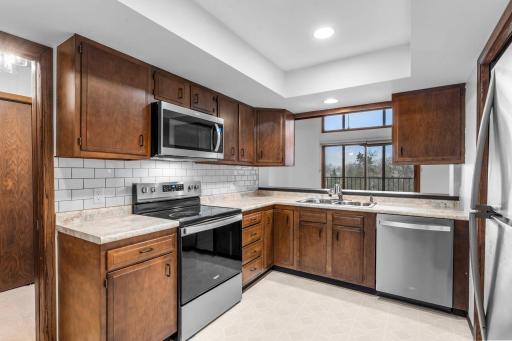 The kitchen offers ample cabinetry and counter space, along with newer stainless steel appliances.