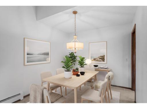 Adjacent to the kitchen is a bright informal dining area with carpeting and a classic chandelier, an ideal spot for enjoying meals. (Digitally staged)