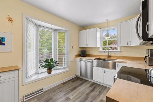 Updated kitchen with stainless steel appliances, farm sink, butcher block countertop and new LVT flooring. South facing bay window
