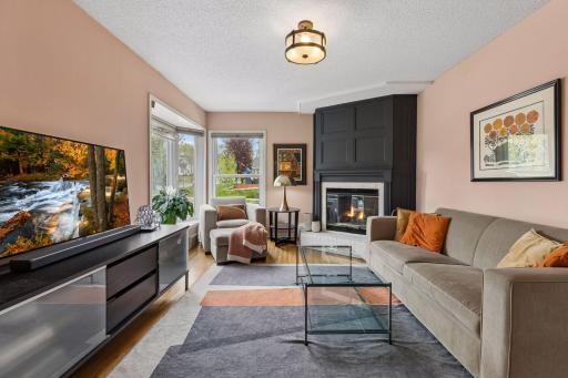 Living room with wood burning fireplace, bay window and corner window allowing lots of natural light