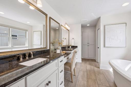 The primary bath is a spa-level retreat featuring a double vanity with stunning granite countertops, designer mirrors, a deep soaking tub in a fully tiled surround shower. Every detail is crafted for pure indulgence.