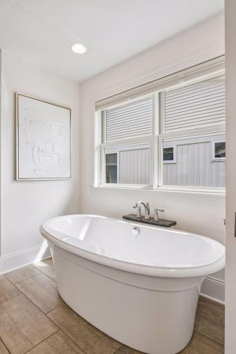 A deep soaking tub offers the kind of refined spa-inspired finish that makes staying home feel like a getaway.