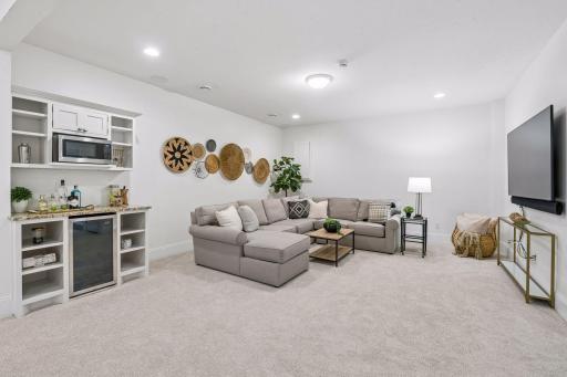 A sprawling entertainment zone with room for a game table, media space, and kitchenette