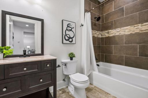 The lower-level guest bath is a charming, beautifully appointed space that delivers style and comfort right where you need it most. A thoughtful finishing touch that makes the lower level truly self-contained and guest ready