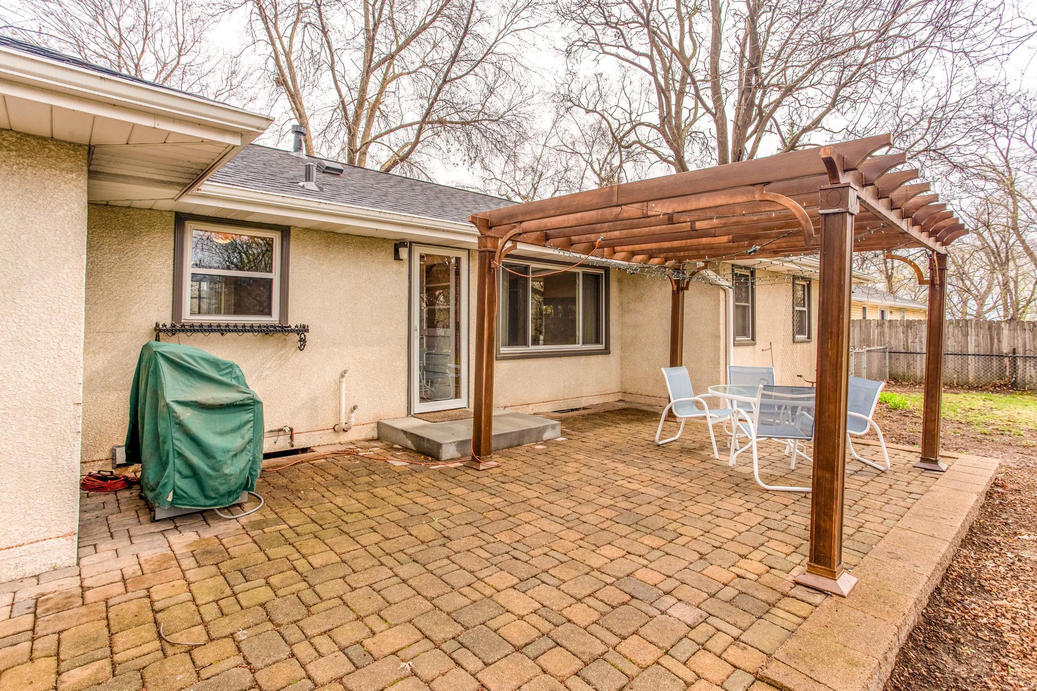 Inviting pergola-covered patio with seating area, creating a comfortable space for shaded outdoor dining and entertaining.