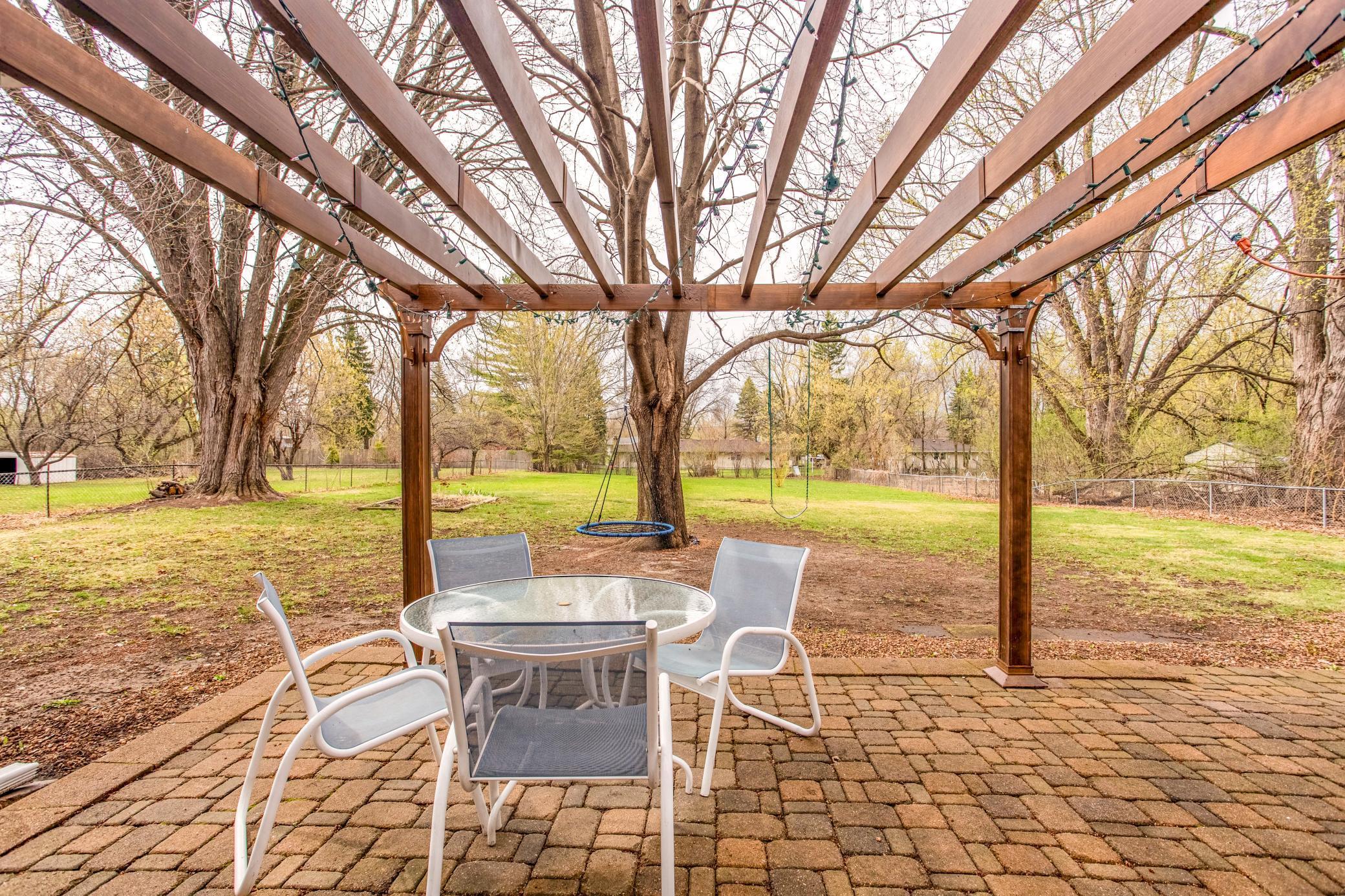Beautiful wood pergola adds character and charm to the patio, offering a cozy spot to relax and unwind.