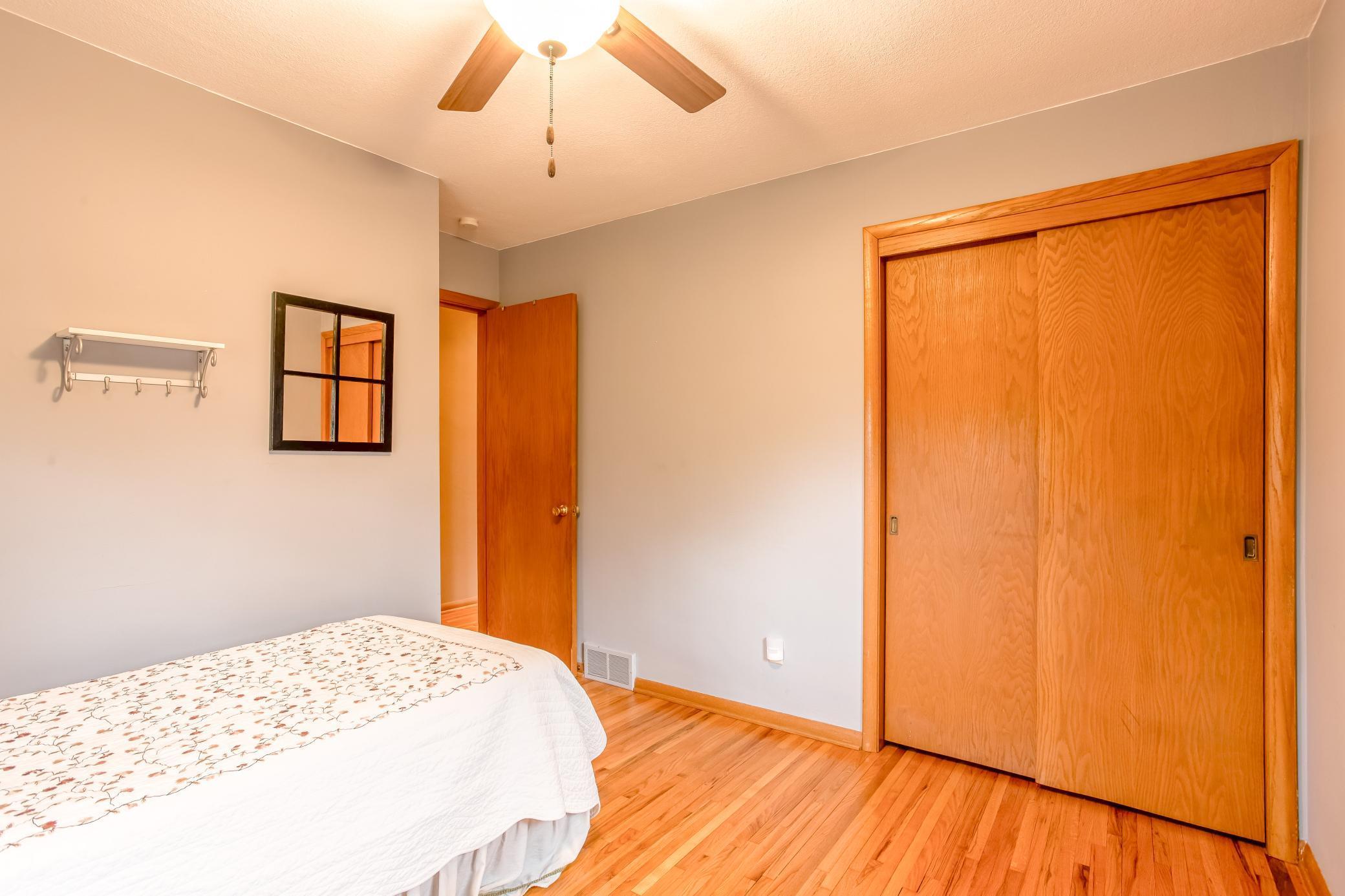 Well-sized bedroom with convenient closet space and warm wood accents.