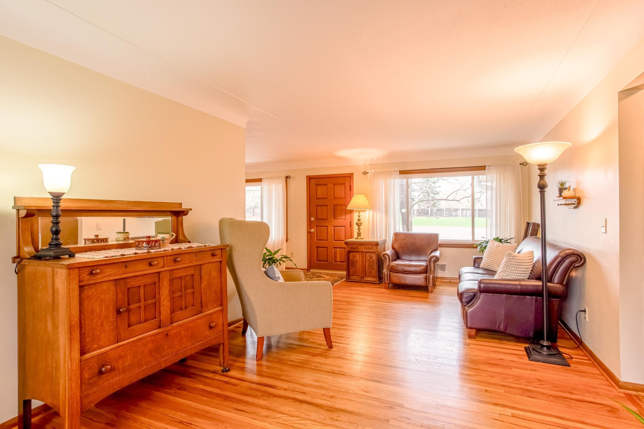 Expansive main-level living space highlighted by natural light and timeless hardwood flooring.