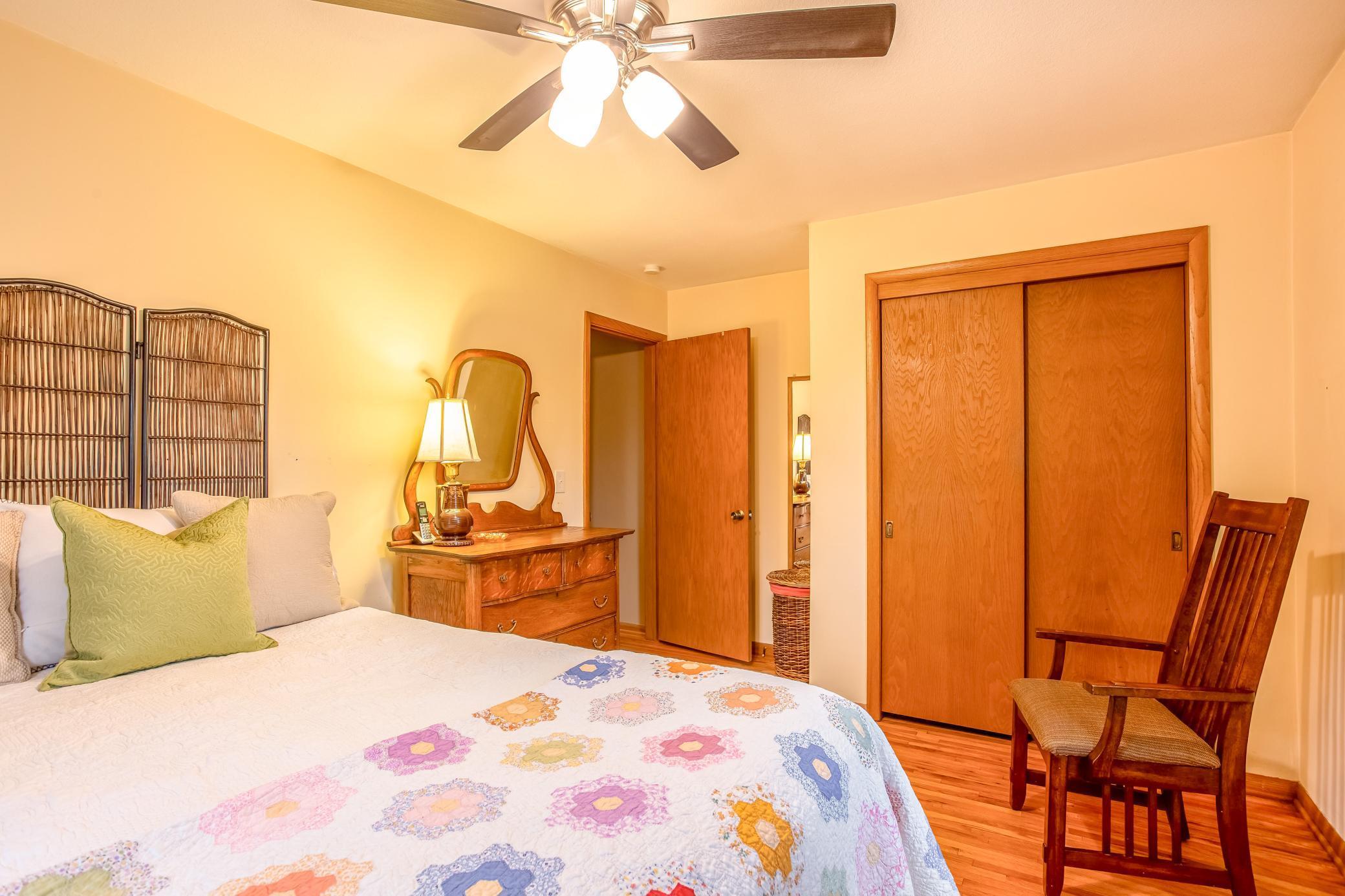 Primary bedroom featuring generous closet space and warm wood accents.