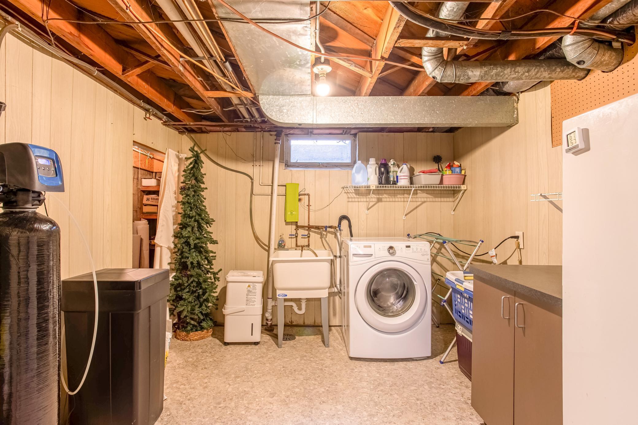 Functional laundry and utility space with utility sink and room for organization.