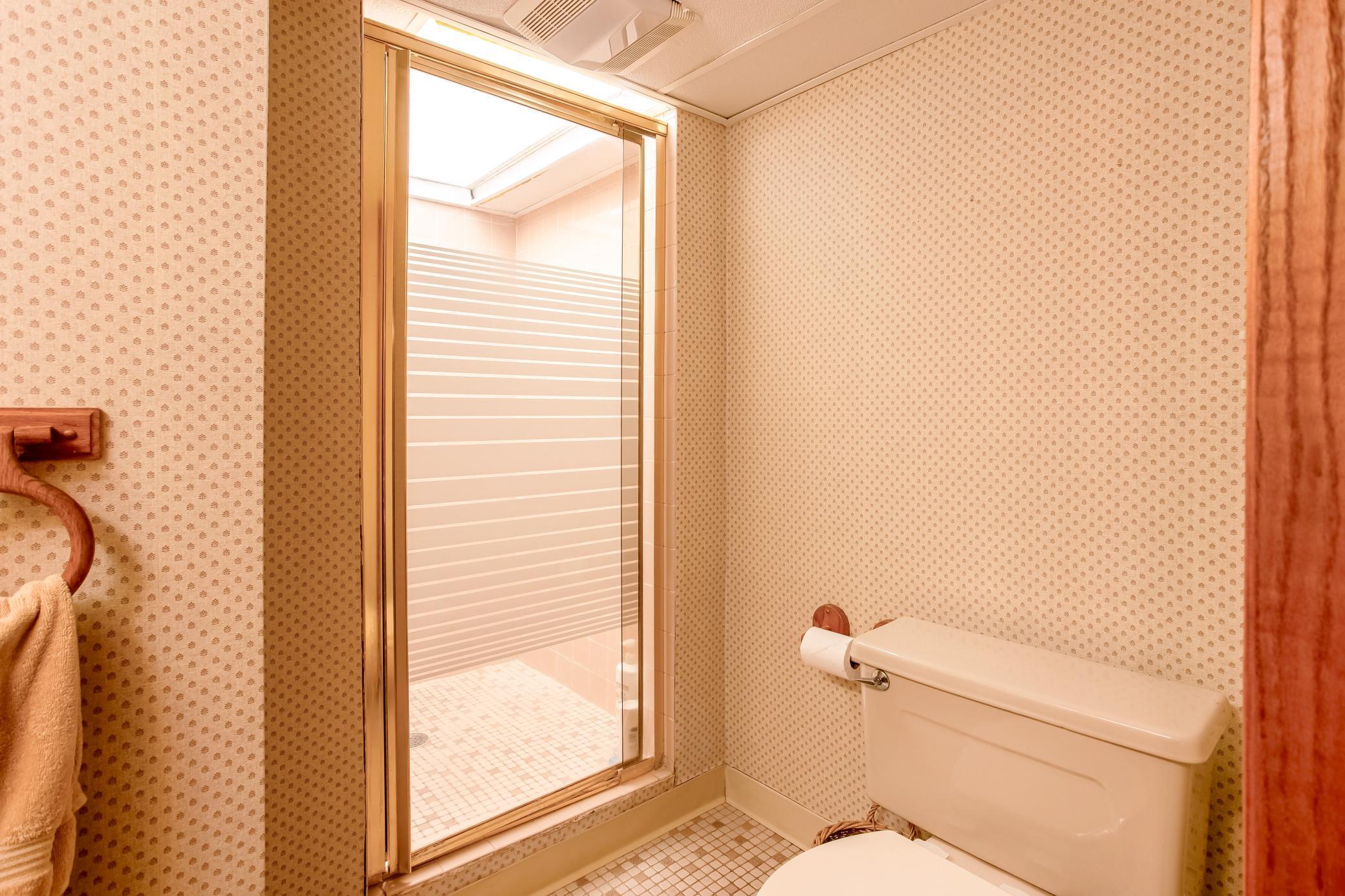 Functional bathroom with vanity storage and walk-in shower.