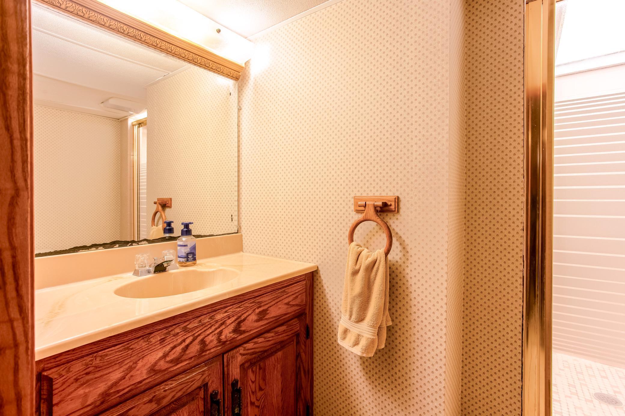 Functional bathroom with vanity storage and walk-in shower.