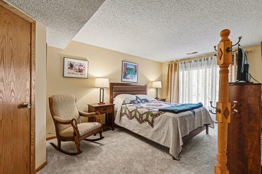 Lower-level bedroom with a large window, natural light and park views