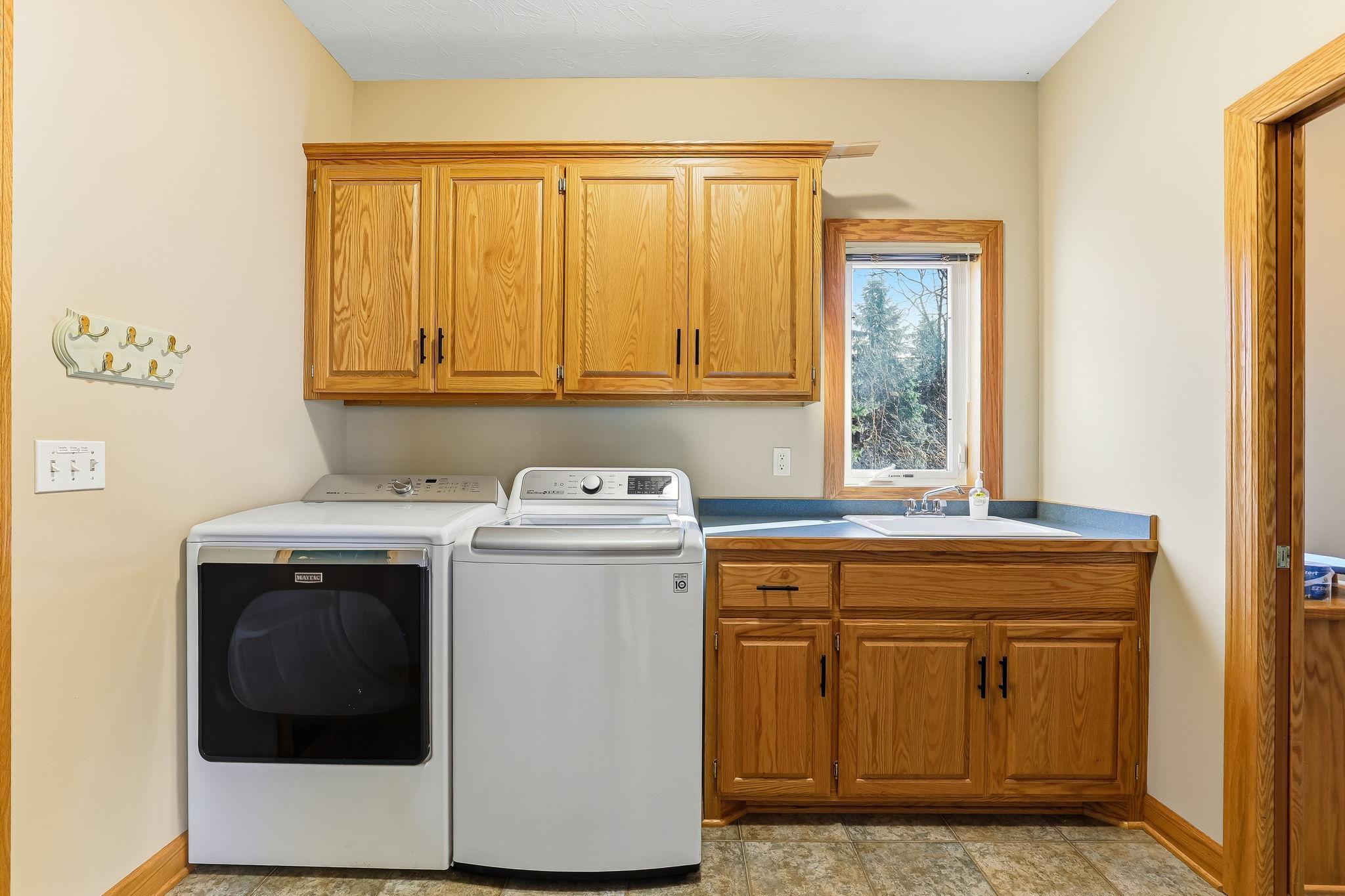 Stylish main-floor laundry elevated by custom cabinetry and a sleek sink