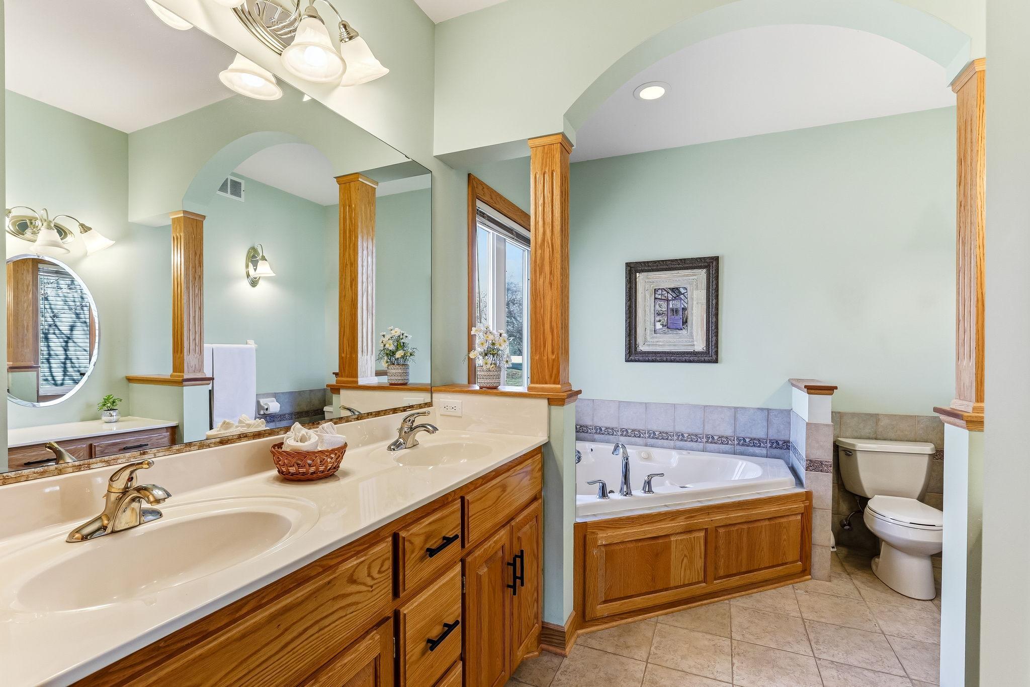 Distinctive design elements—arched detailing and columns—create a refined, spa-like owner’s bath.