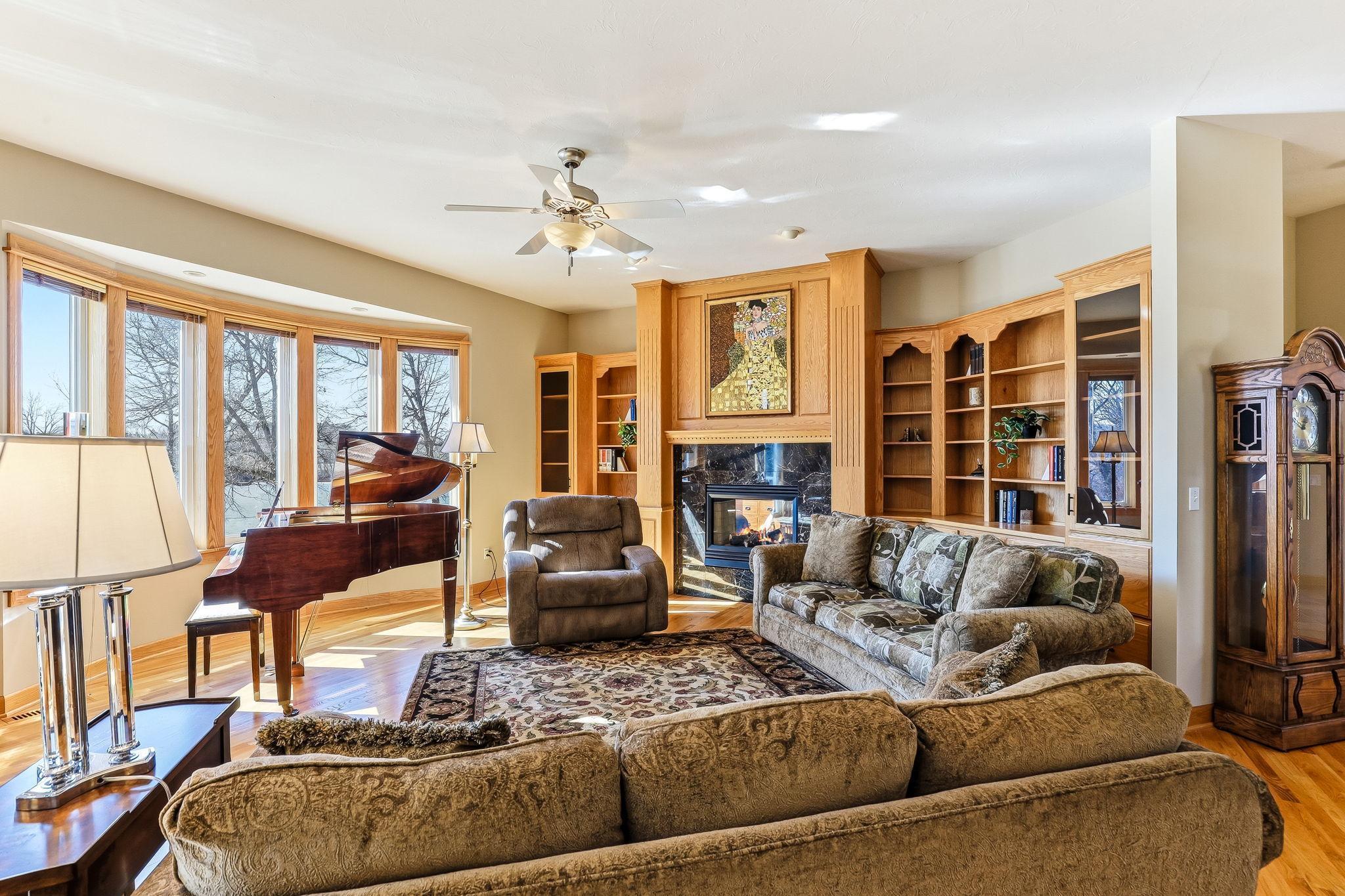 Striking see-through fireplace accented by a sleek black ceramic surround and oak mantel